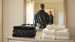  Person in thick robe smiling in sunlit bedroom, highlighting robe thickness options