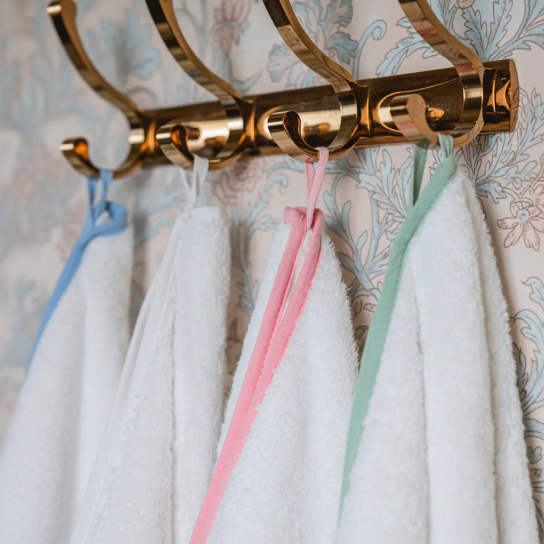 White oversized bath sheets with blue pink and mint scallop piping hung on gold hooks for effortless spa-quality comfort - Lotus Linen