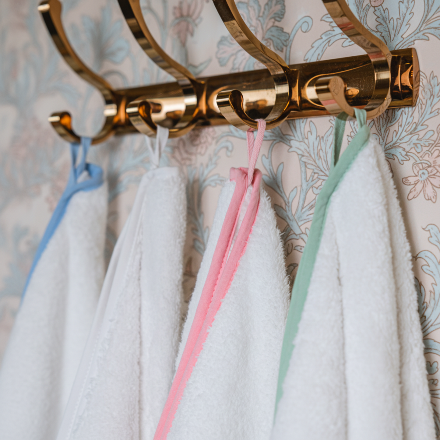 White oversized bath sheets with blue pink and mint scallop piping hung on gold hooks for effortless spa-quality comfort - Lotus Linen