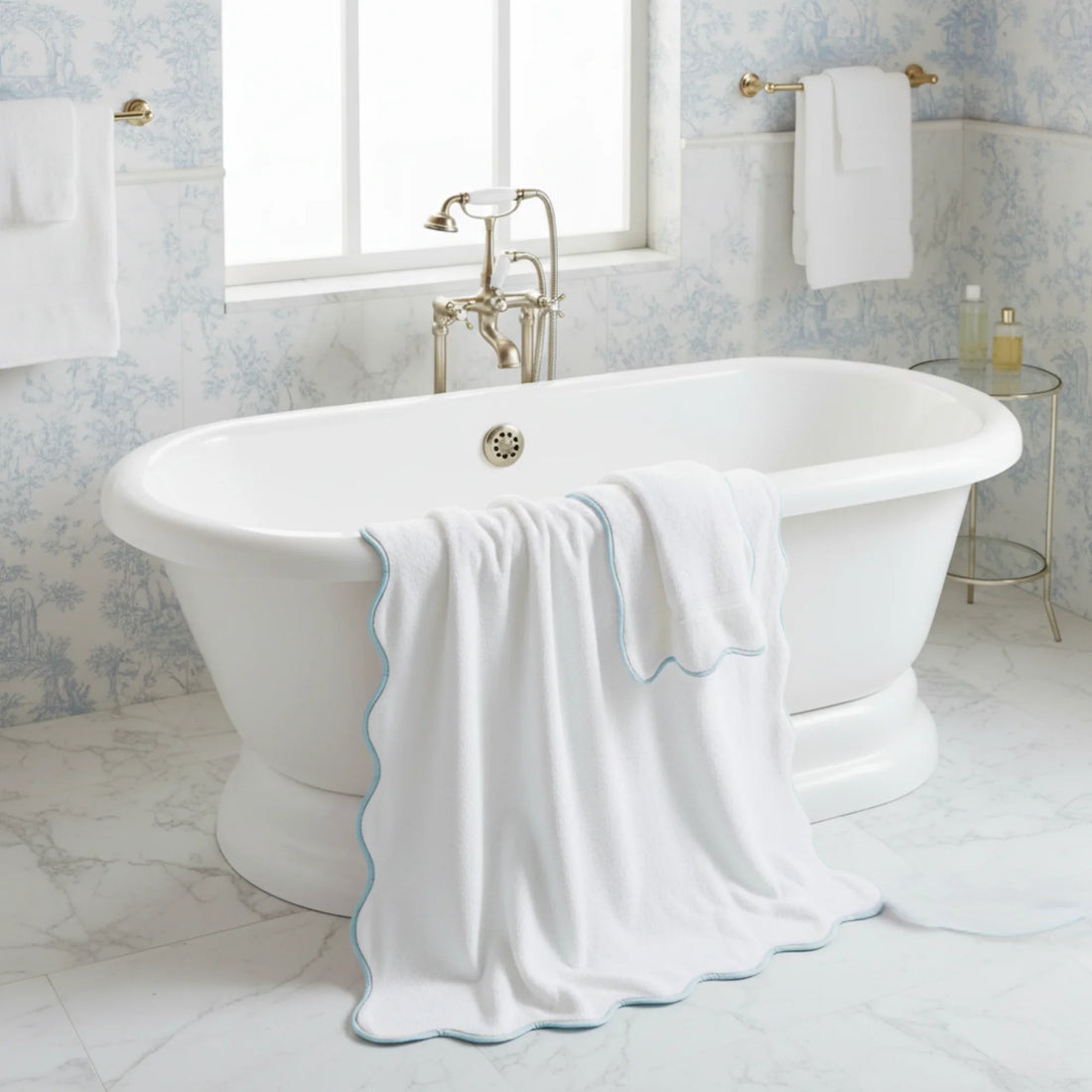 Oversized scallop-piped bath sheet in white with blue trim draped over freestanding tub for spa-quality comfort - Lotus Linen