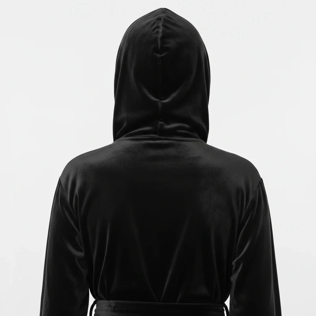 Woman wearing black plush hooded robe shown from behind, enveloping softness for spa-worthy relaxation - Lotus Linen