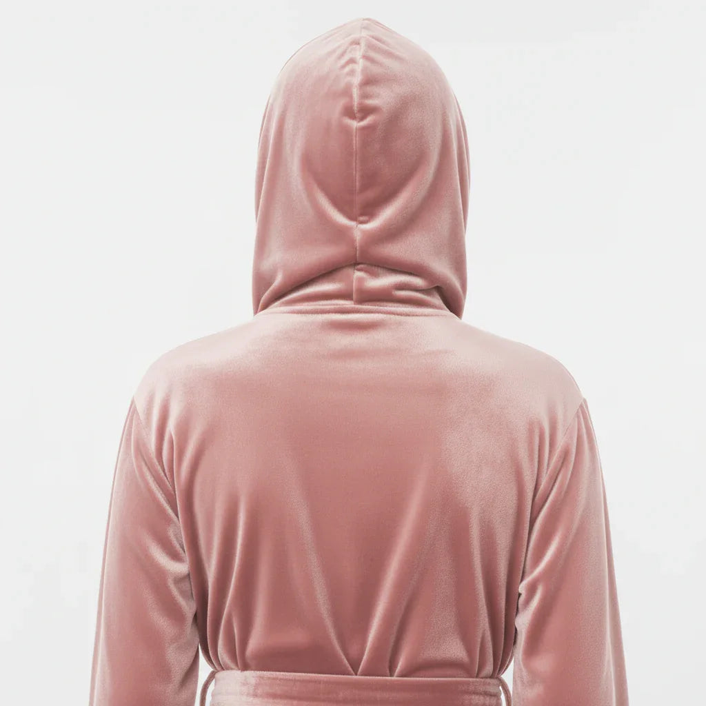 Woman wearing blush pink plush hooded robe shown from behind for cozy spa-worthy relaxation at home - Lotus Linen