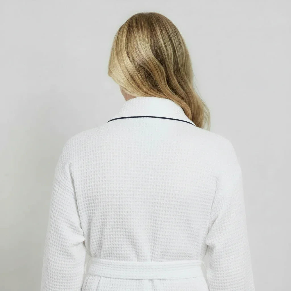 Woman wearing white waffle-knit knee-length robe with navy trim for spa-quality comfort at home - Lotus Linen