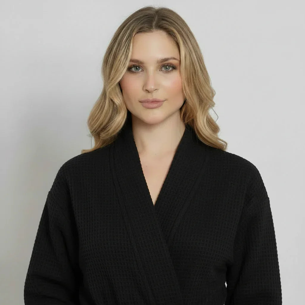 Woman modeling black waffle-weave knee-length robe with cozy spa-quality comfort - Lotus Linen