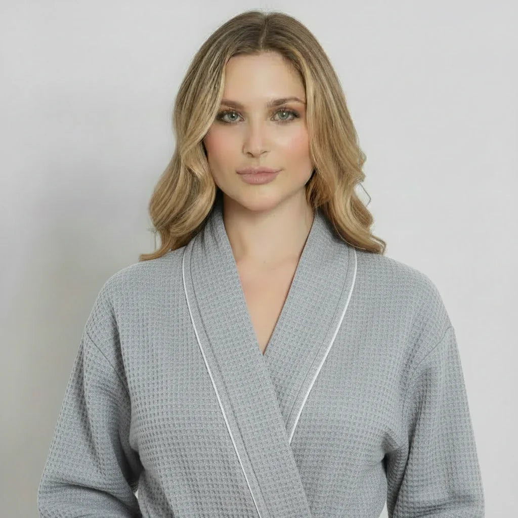 Woman in grey waffle-knit knee-length robe with white piping for effortless spa-quality comfort at home - Lotus Linen