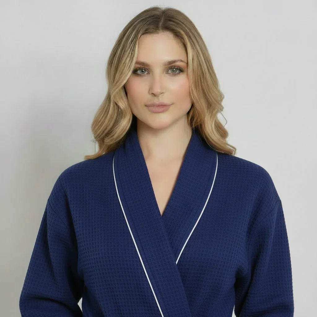 Woman in navy waffle-knit knee-length robe with white piping for effortless spa-quality comfort - Lotus Linen
