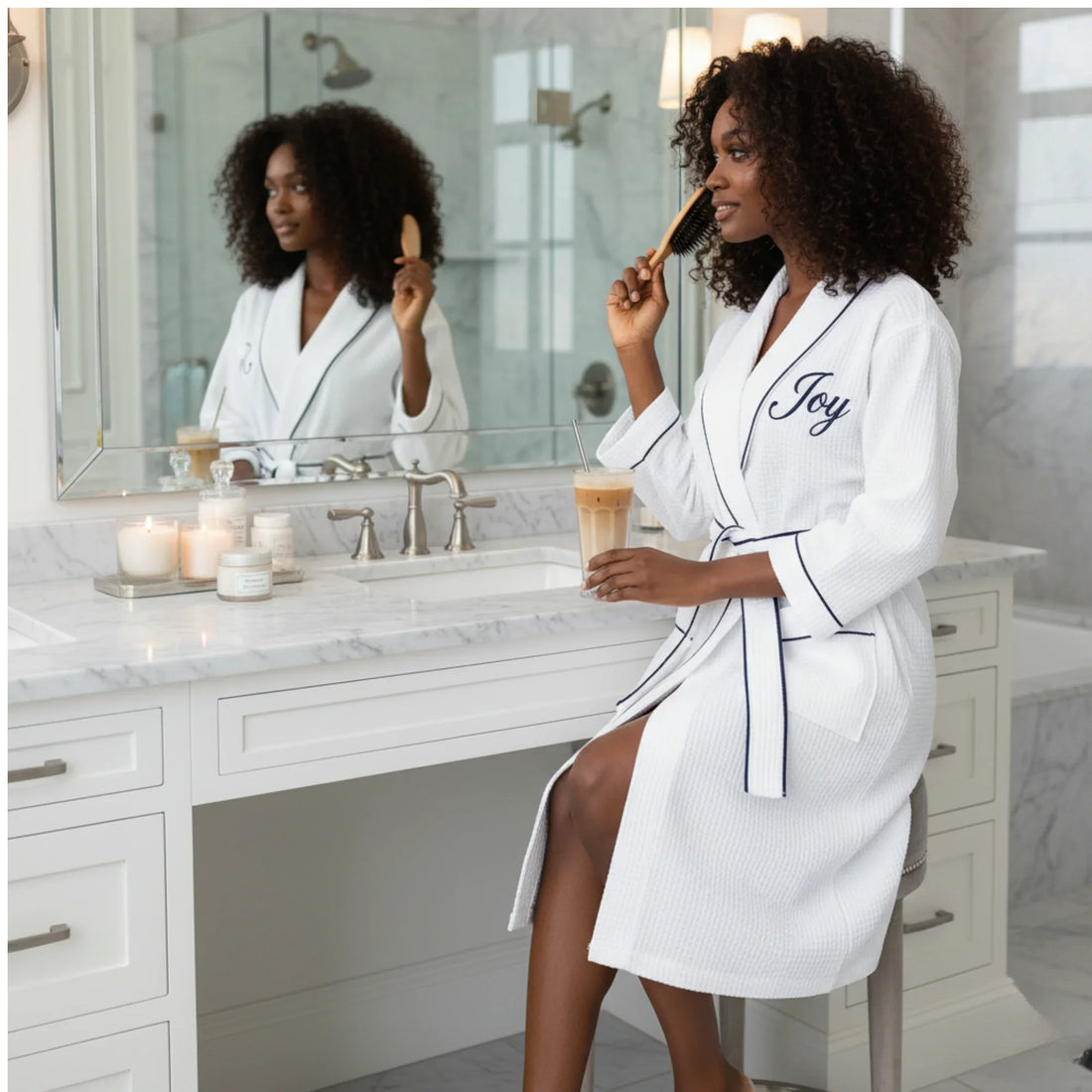 Woman in personalized white waffle knee-length robe with navy trim enjoying spa-quality comfort at her vanity - Lotus Linen