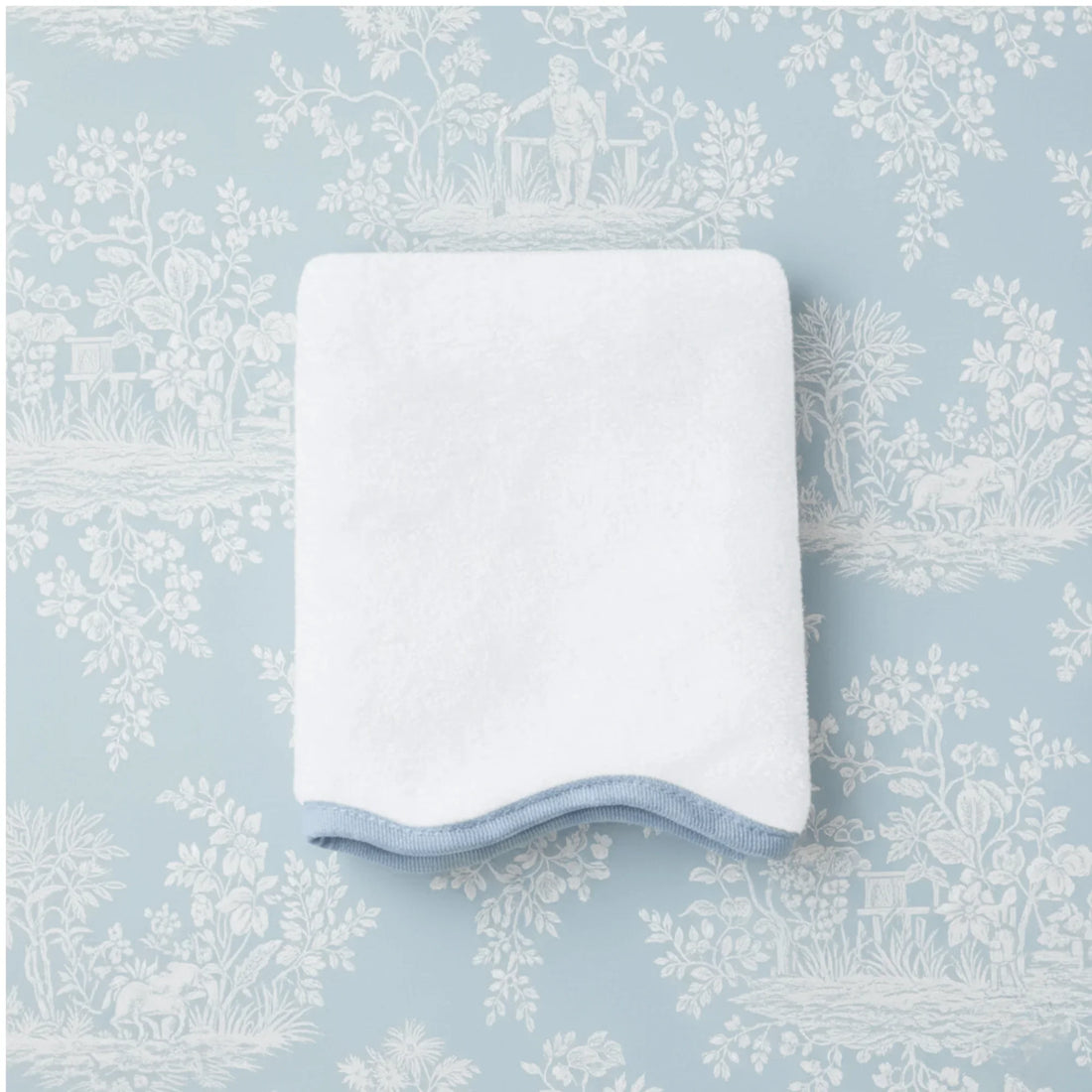 Folded white bath towel with blue scalloped trim offering spa-quality softness and plush absorbency - Lotus Linen